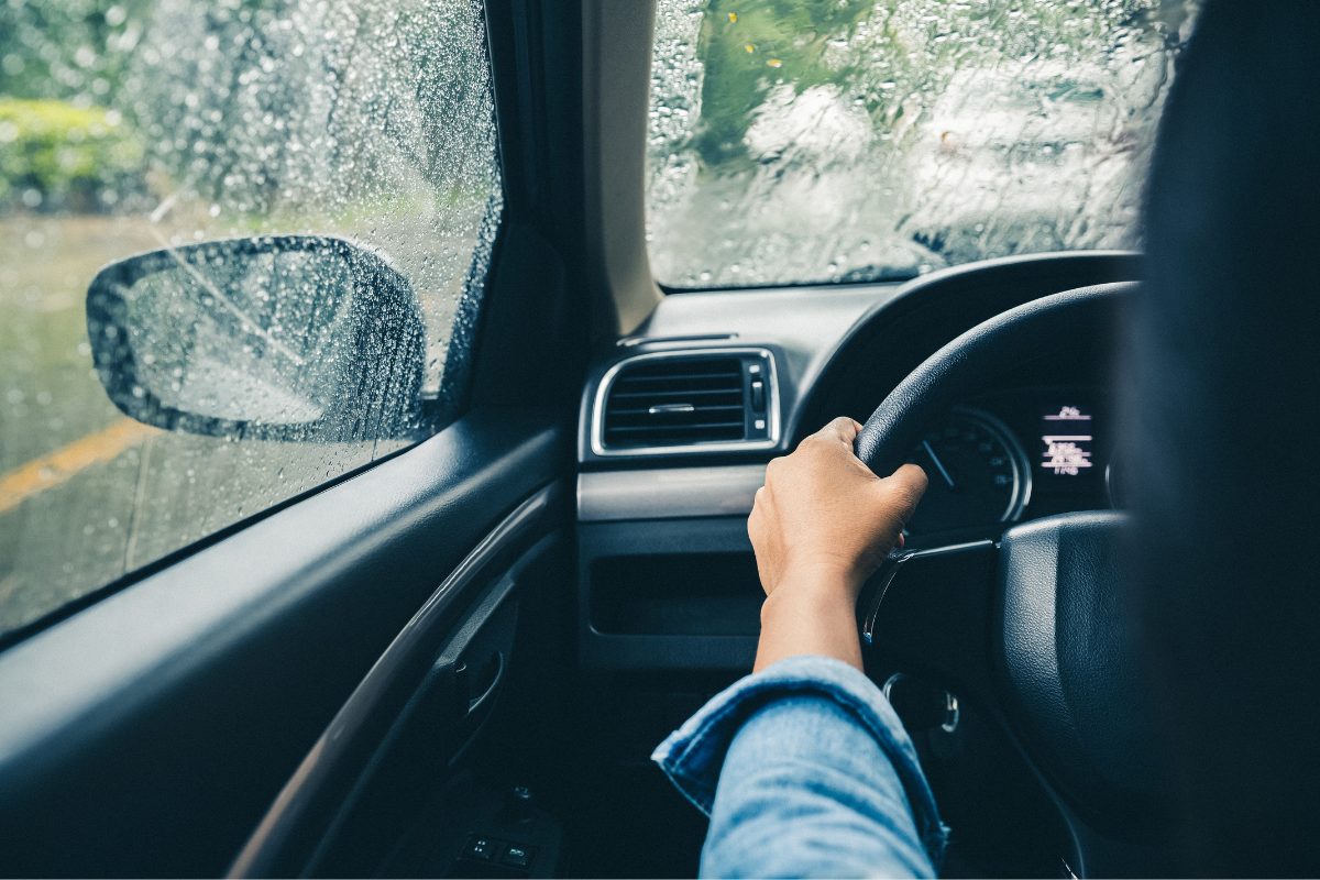 Person driving car in the rain